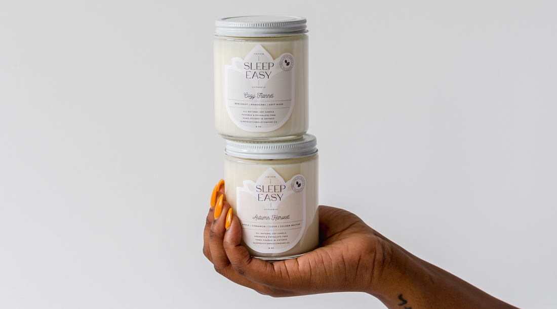 a woman is holding two candle in her palm in one hand in front of a white wall