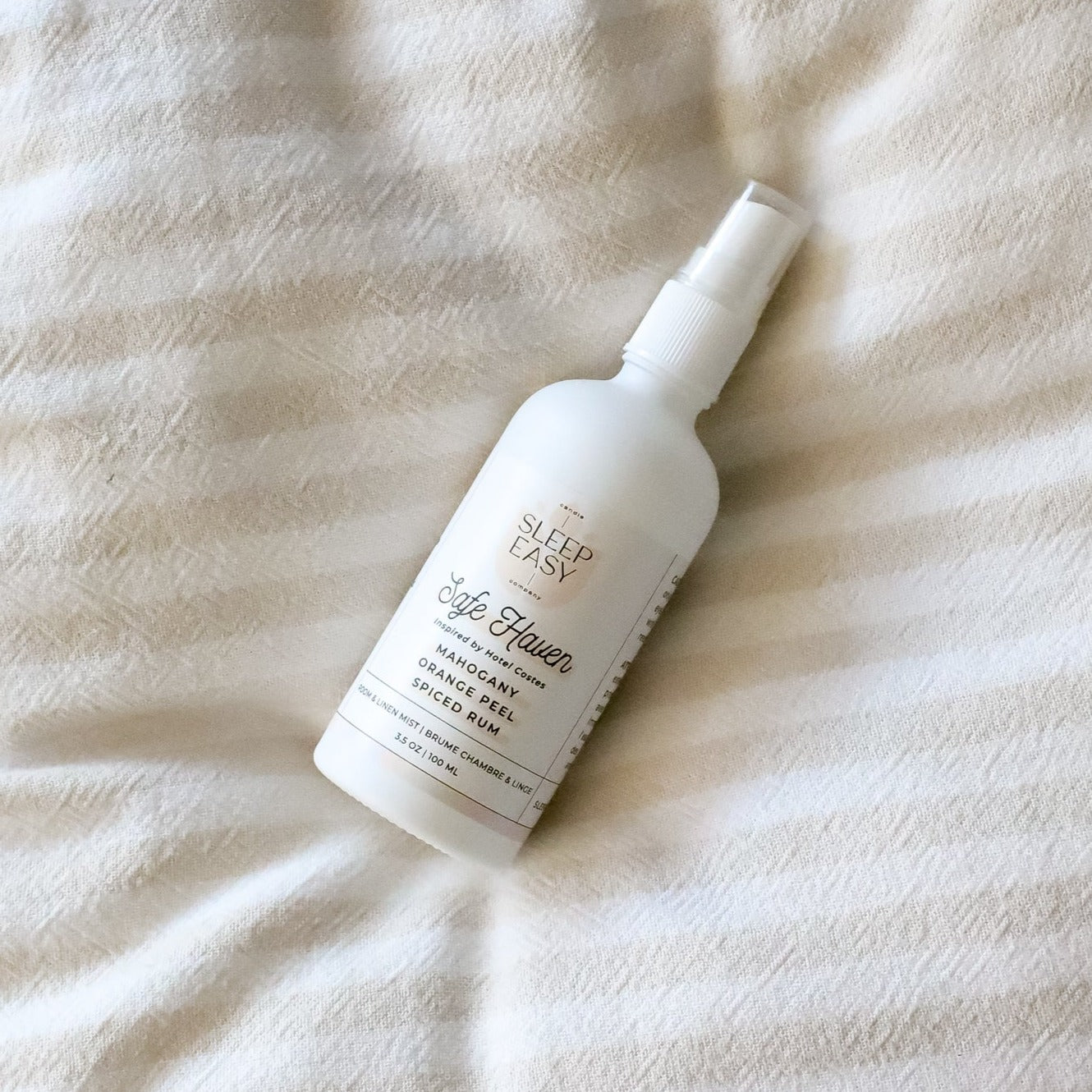 Safe Haven Room & Linen Mist laying on top of a linen sheet.