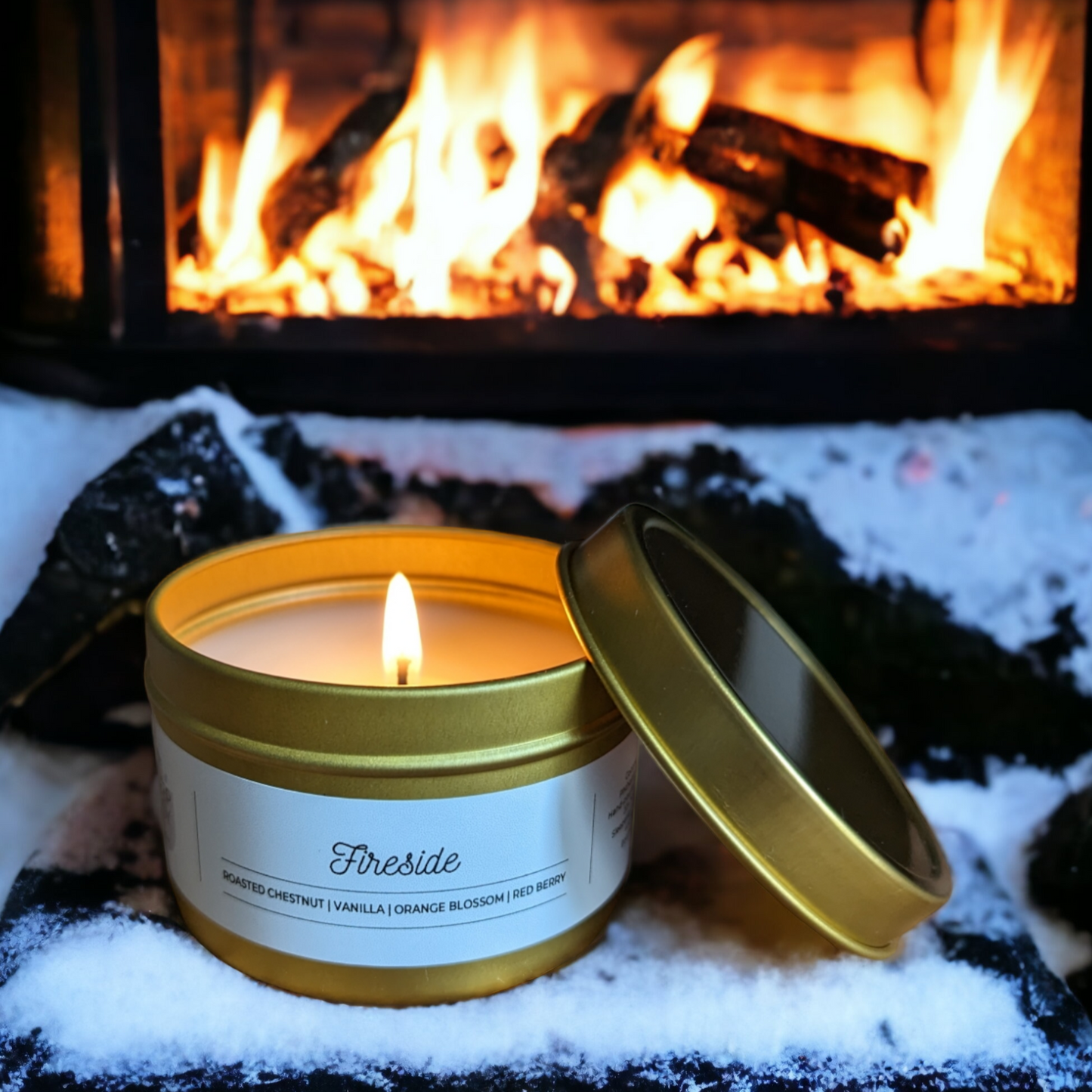 4oz gold travel tin candle is displayed in front of a roaring fireplace. Our Fireside coconut soy candle is inspired by Replica Maison Margiela By The Fire Perfume. 